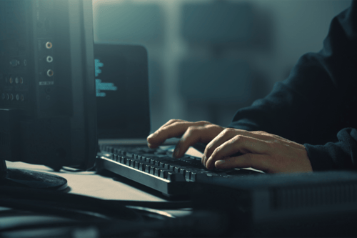 Person typing on a computer keyboard.